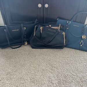 Twenty-seven (27) new and gently-used Michael Kors bags in various colors